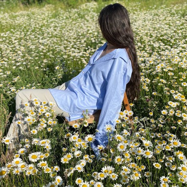 Person stretching gently outdoors with a serene landscape.